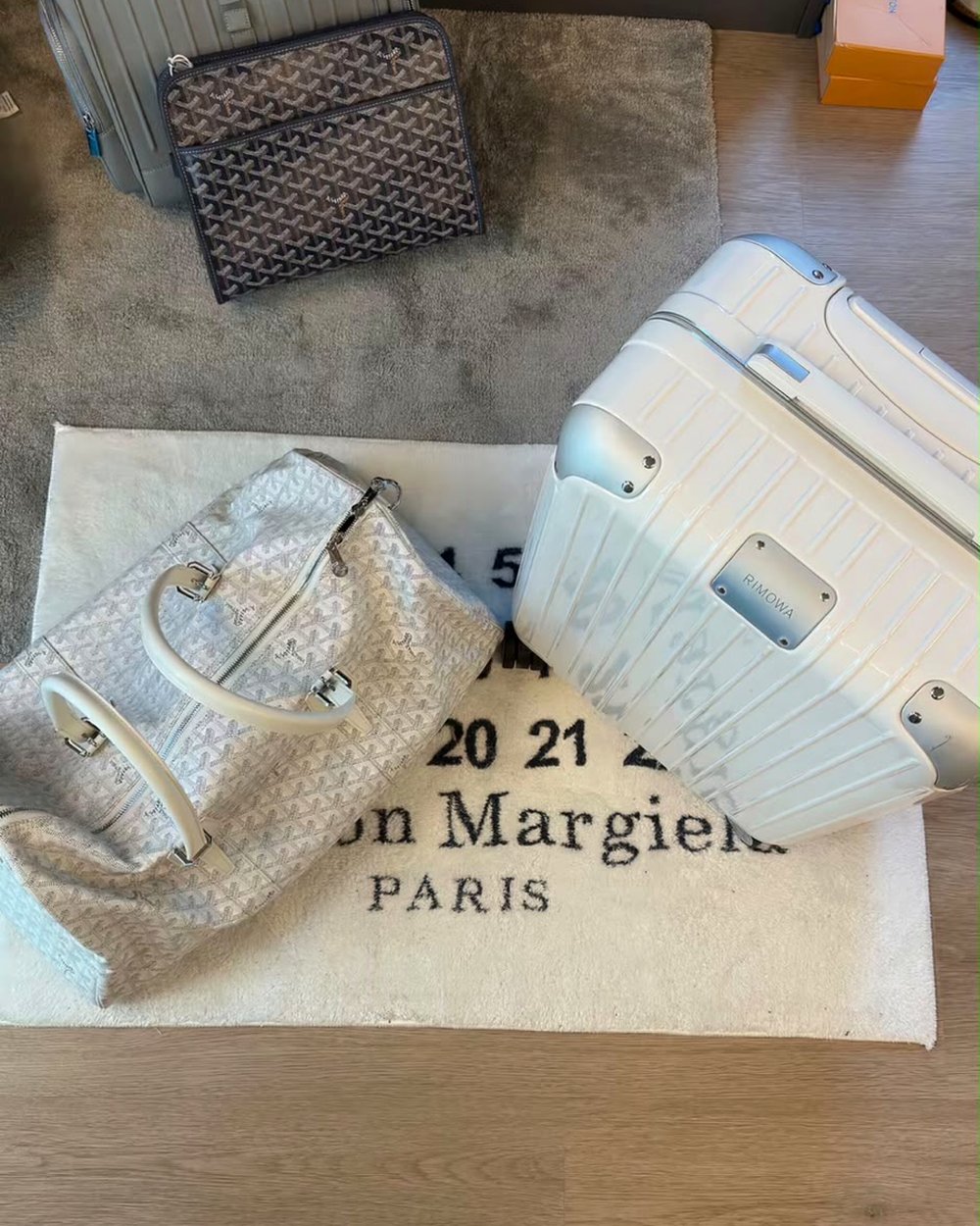 Bolsa de viagem, nécessaire e mala rígida sobre tapete claro